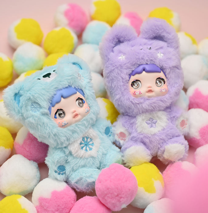 Two colorful plush toys with bear ears on a background of pastel-colored balls. nommi. key chain