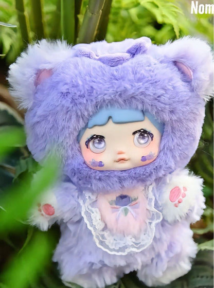 Plush toy with purple fur and white accents, sitting on a green leafy background.Nommi V3 Interesting Fruit Dolls Series Dolls plush blind box — Blueberry (purple/lilac) — Kuwait — نومي