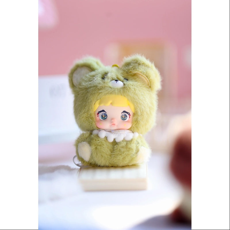Small plush toy with bear ears and a doll body on a white surface with a pink background, Nommi V4 Baby Series plush key chain blind box — Grape Baby (light green) — Kuwait — نومي — Maibo