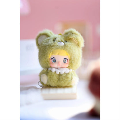 Small plush toy with bear ears and a doll body on a white surface with a pink background, Nommi V4 Baby Series plush key chain blind box — Grape Baby (light green) — Kuwait — نومي — Maibo