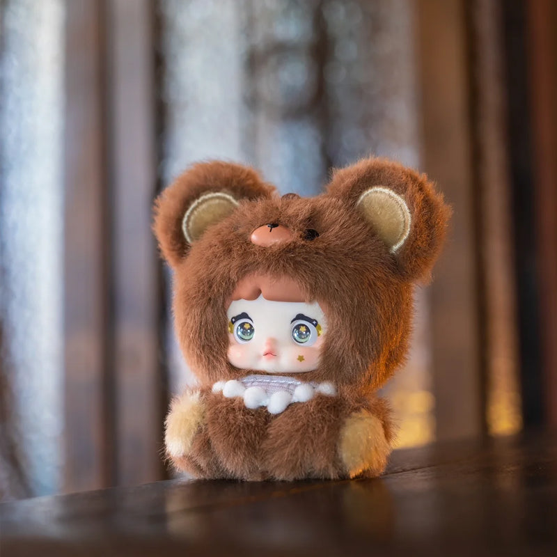 Small plush toy with a bear costume on a wooden surface, Nommi V4 Baby Series plush key chain blind box — Mocha Baby (brown) — Kuwait — نومي — Maibo