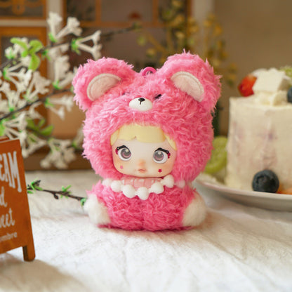 Pink teddy bear plush toy with a doll's face on a table with decorative items in the background,Nommi V4 Baby Series plush key chain blind box — Straw Baby (rose pink) — Kuwait — نومي — Maibo